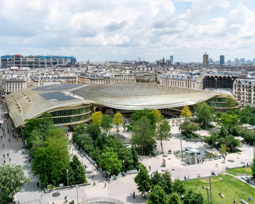 Vue aérienne du Jardin Nelson Mandela verdoyant et de la Canopée des Halles de Paris avec des Panneaux photovoltaïques sur les côtés de son toit de verre.